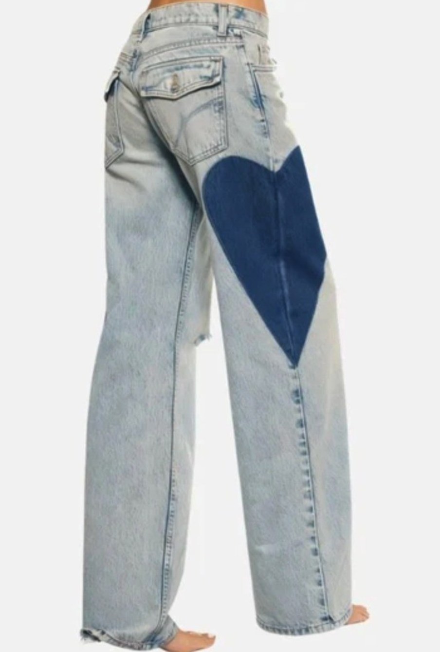 Flat lay of Telepatia Jeans denim styles showing heart patch detail, contrast stitching, and vintage wash finishes